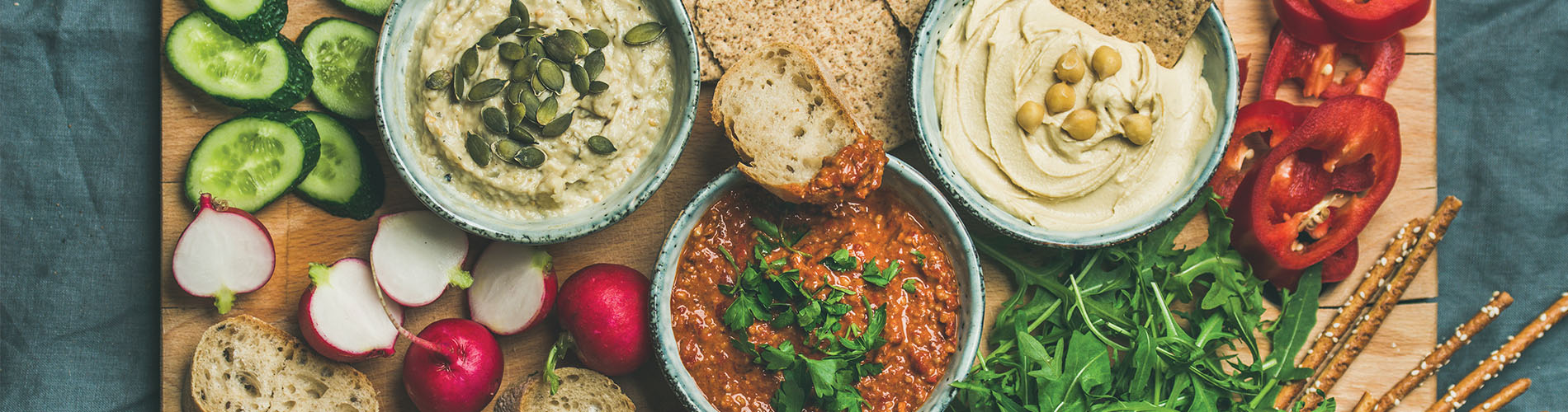 Spread of exotic dips with vegetables and bread