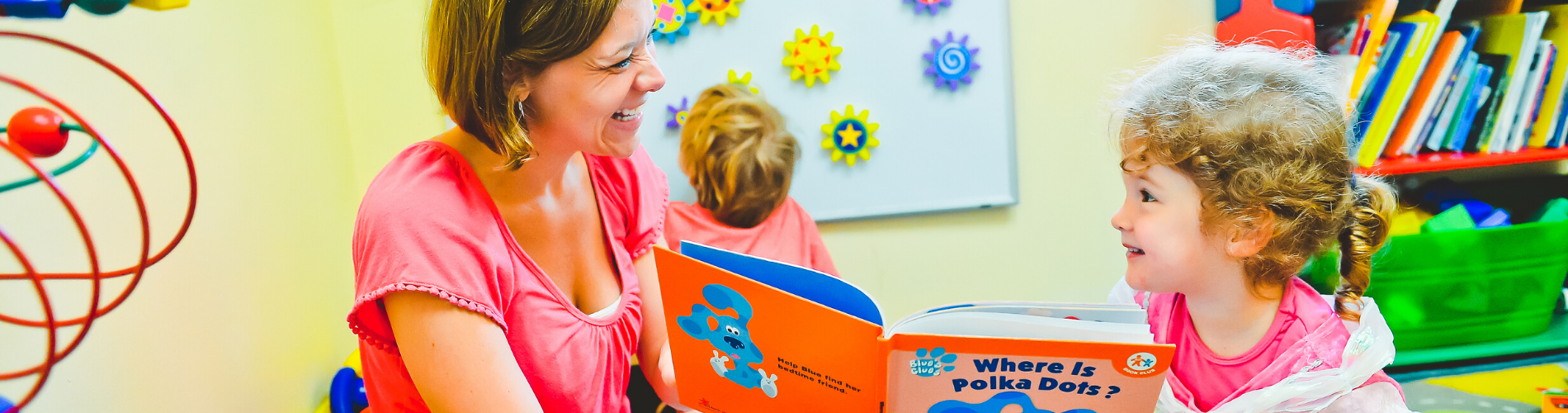 Little girl reading with her mother
