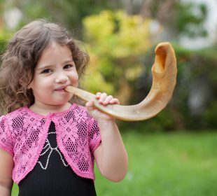 Little girl blowing the shofar