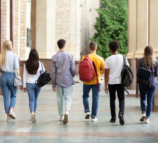 Group of students walking in college campus after classes