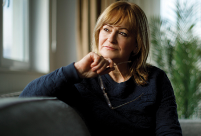 Portrait of worried senior woman sitting on sofa