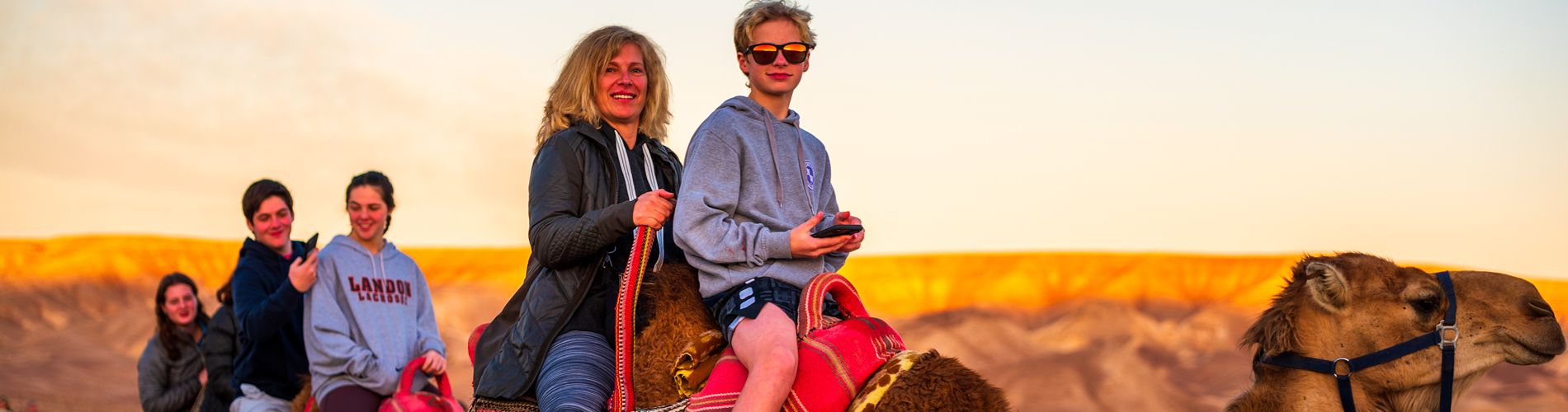 family mission people riding on camels in israel