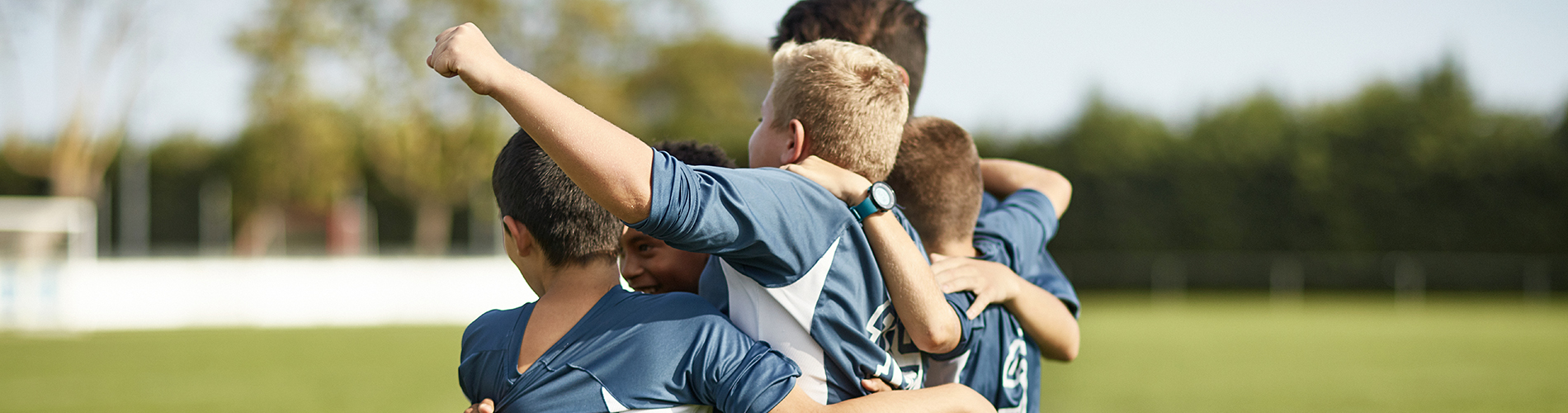 boys sports team cheering and hugging