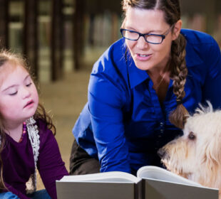 Children in library with reading assistance dog