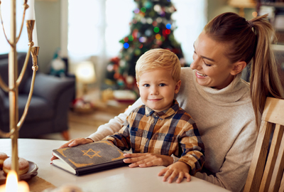 small boy and his mother reading Hebrew Bible with chrismas tree in background