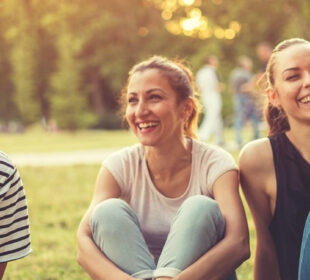 Three friends sitting in the park,laughing and having a great time