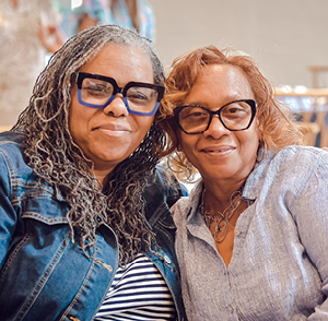 2 women employees smiling at event