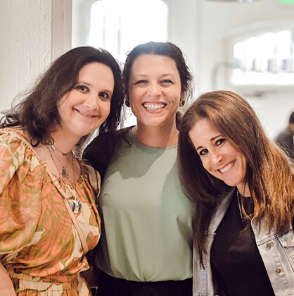 3 women employees smiling at an event