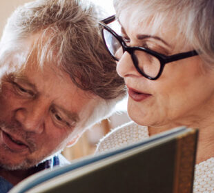 Grandparents reading book to granddaughter