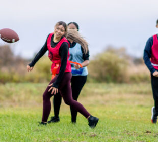 young adults playing flag football