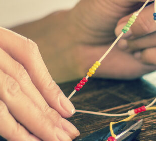 Woman making beaded bracelet craft