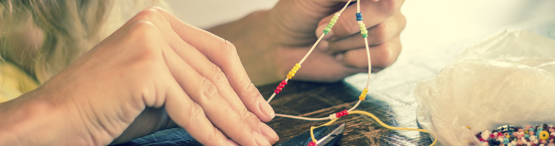 Woman making beaded bracelet craft