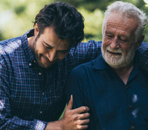 Senior father and adult son embracing