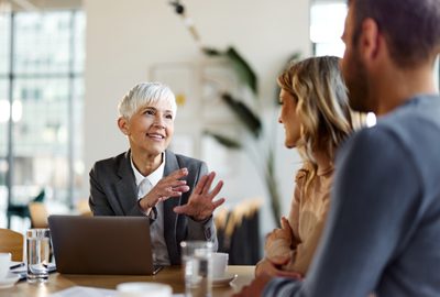 female advisor talking to a couple on a meeting in the office