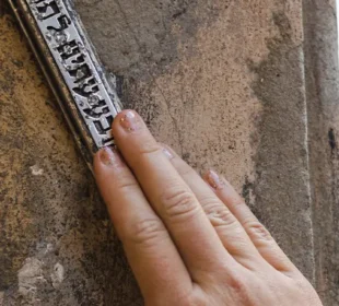 Woman touching mezuzah in doorway