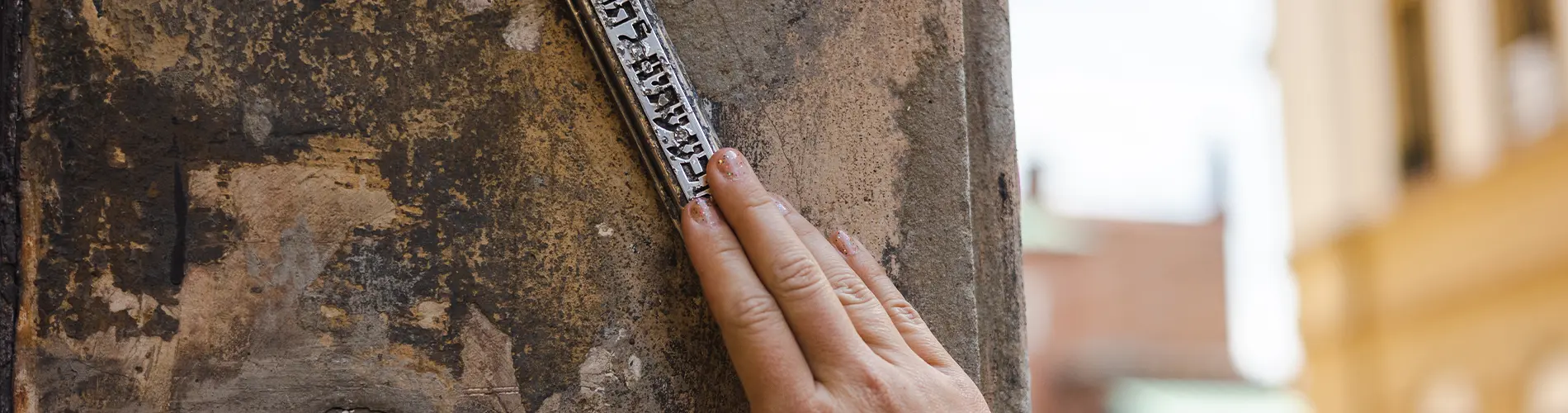 Woman touching mezuzah in doorway