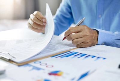 Businessman reading business contract and checking investment charts