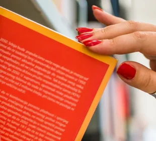 Woman reaching for book at library