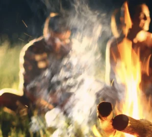 Young adults around a campfire