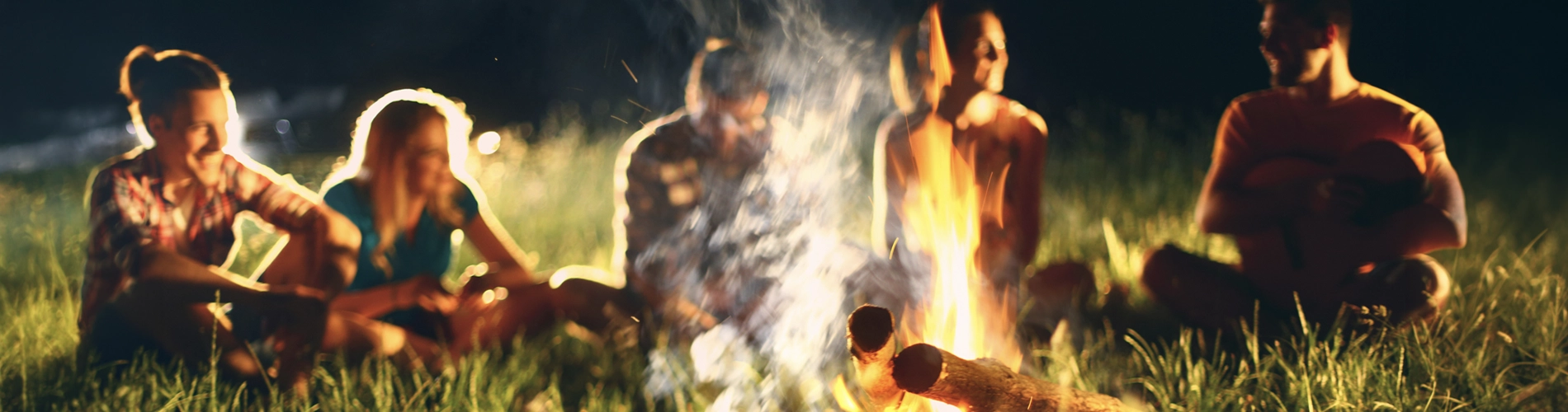 Young adults around a campfire