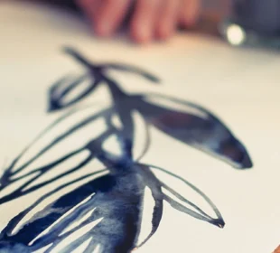 woman's hand painting on paper