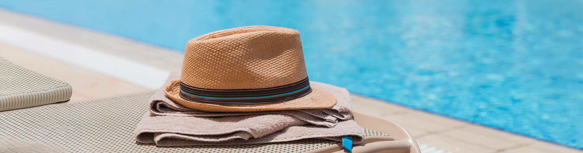 Hat and towel at the edge of a pool
