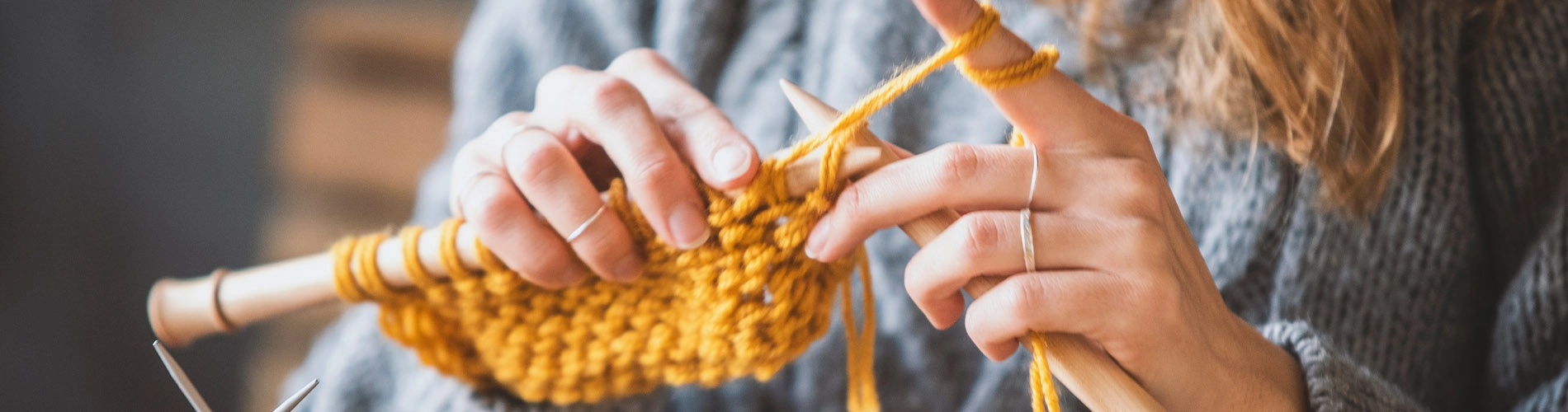 woman knitting with yellow yarn
