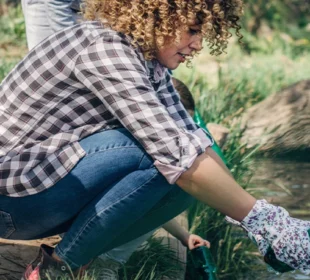 Volunteer cleaning up trash in stream
