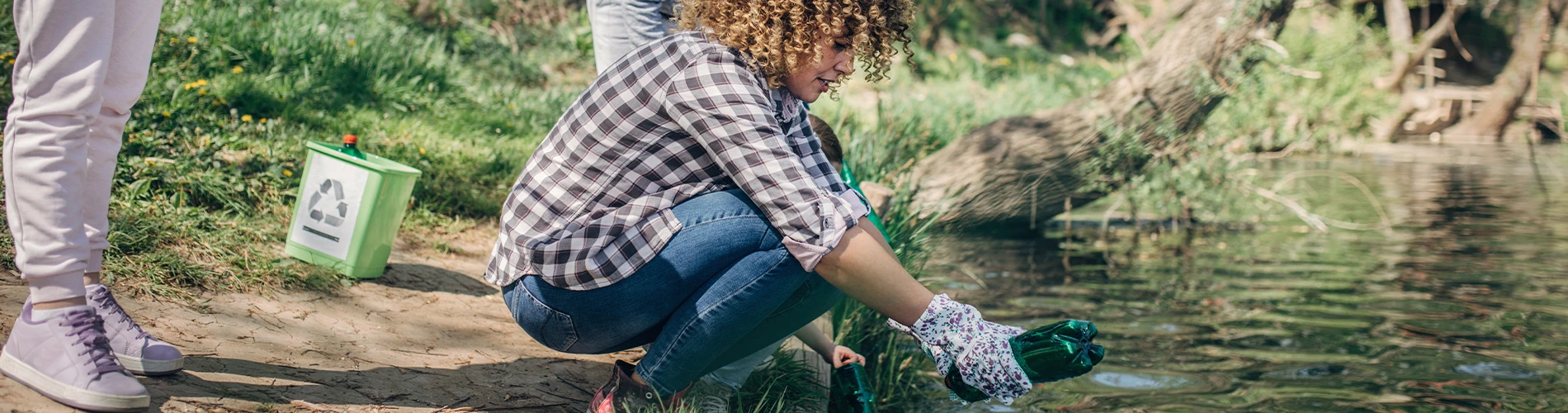 Volunteer cleaning up trash in stream